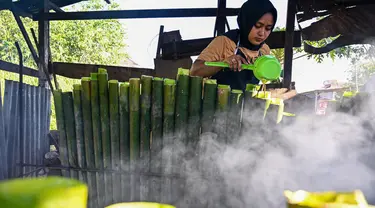 Seorang pekerja memasak Lemang untuk berbuka puasa Ramadan, Banda Aceh pada tanggal 29 Maret 2024. (CHAIDEER MAHYUDDIN/AFP)