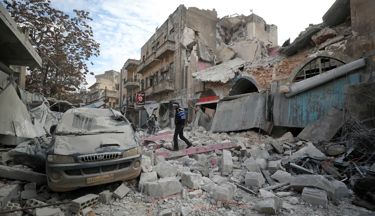 Warga berjalan melewati puing-puing bangunan setelah serangan udara rezim di Kota Ariha, Idlib, Suriah, Rabu (15/1/2020). Pada 9 Januari, gencatan senjata di Idlib dideklarasikan dengan inisiatif Rusia dan Turki. (Omar HAJ KADOUR/AFP)