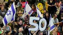 Seorang demonstran memegang angka "50", yang merujuk pada jumlah sandera yang masih berada di Jalur Gaza sejak serangan 7 Oktober 2023 oleh milisi Hamas, selama protes anti-pemerintah di luar markas besar Kementerian Pertahanan Israel di Tel Aviv pada 28 Juni 2025. (Jack GUEZ/AFP)