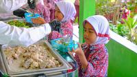 Anak-anak SDN Kosambi, Kampung Kosambi 2, Desa Karang Suraga, Kecamatan Cinangka, Kabupaten Serang, mengantre untuk mendapatkan makan siang bergizi di sekolah. (dok. Archipelago)