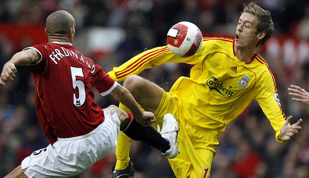 Striker Liverpool, Peter Crouch, berebut bola dengan bek Manchester United, Rio Ferdinand, pada laga Liga Premier Inggris di Stadion Old Trafford, Inggris, Minggu (22/10/2006). (AFP/Andrew Yates)