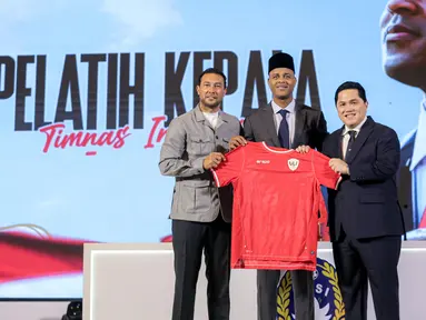 Pelatih kepala baru Timnas Indonesia, Patrick Kluivert (tengah) berfoto bersama ketua umum PSSI, Erick Thohir (kanan) dan asisten pelatih baru Timnas Indonesia, Denny Lanzaat berfoto bersama sambil memegang jersey pada acara konferensi pers mengenai perkenalan pelatih baru Timnas Indonesia di Hotel Mulia, Senayan, Jakarta, Minggu (12/01/2025). (Bola.com/Bagaskara Lazuardi)