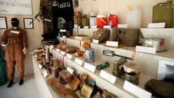 Baju tempur, bendera, senjata, hingga pakaian untuk bom bunuh diri yang pernah digunakan ISIS di sebuah museum di Erbil, Irak, 12 Mei 2019. Museum itu memamerkan memorabilia perang dan benda-benda yang berhasil direbut dalam pertempuran dengan ISIS. (REUTERS/Azad Lashkari)