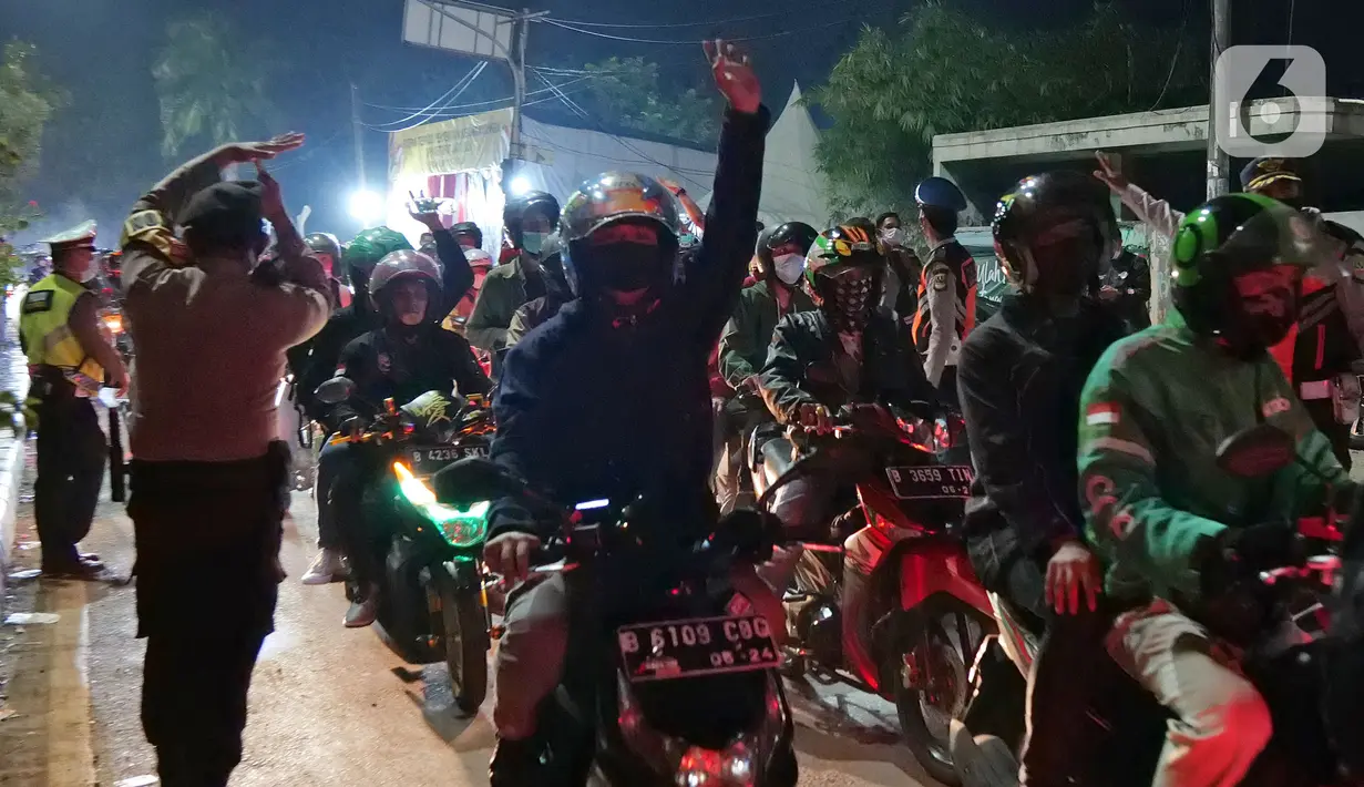 Pemudik motor melintas di posko penyekatan mudik di Kedungwaringin, Kabupaten Bekasi, Jawa Barat, Selasa (11/5/2021) dini hari. Polisi kembali memberlakukan diskresi terhadap pemudik motor yang melintasi jalur Pantura antara Kabupaten Bekasi dan Kabupaten Karawang. (Liputan6.com/Herman Zakharia)