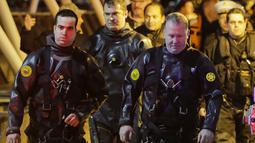 Petugas bersiap mengevakuasi korban jatuhnya helikopter di East River di New York City, AS (11/3). Untuk mengevakuasi korban, petugas penyelam dikerahkan di sekitar lokasi helikopter jatuh. (Eduardo Munoz Alvarez/Getty Images North America/AFP)