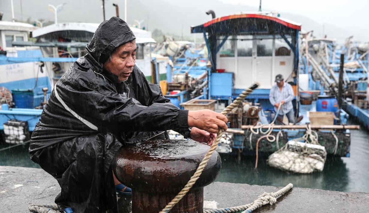 Seorang nelayan mengamankan perahunya saat Topan Kong-rey mendekati Taiwan, di wilayah Yilan pada 30 Oktober 2024. (I-Hwa CHENG/AFP)