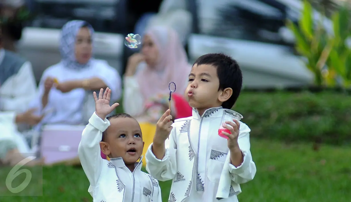 Dua orang anak memainkan bola sabun usai pelaksanaan Salat Idul Fitri 1437 H di Kebun Raya Bogor, Rabu (6/7). Pemerintah Kota Bogor menyelenggarakan Salat Idul Fitri 1437 H yang dipusatkan di Kebun Raya. (Liputan6.com/Helmi Fithriansyah) 