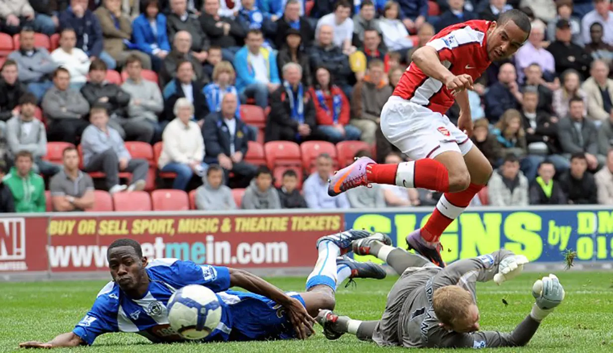 Pemain Arsenal, Theo Walcott mencetak gol ke gawang Wigan pada laga Liga Inggris di Stadion DW, Minggu (18/4/2010). Walcott kerap melewati pemain bertahan dengan mengadu kecepatan. (AFP Photo/Andrew Yates)