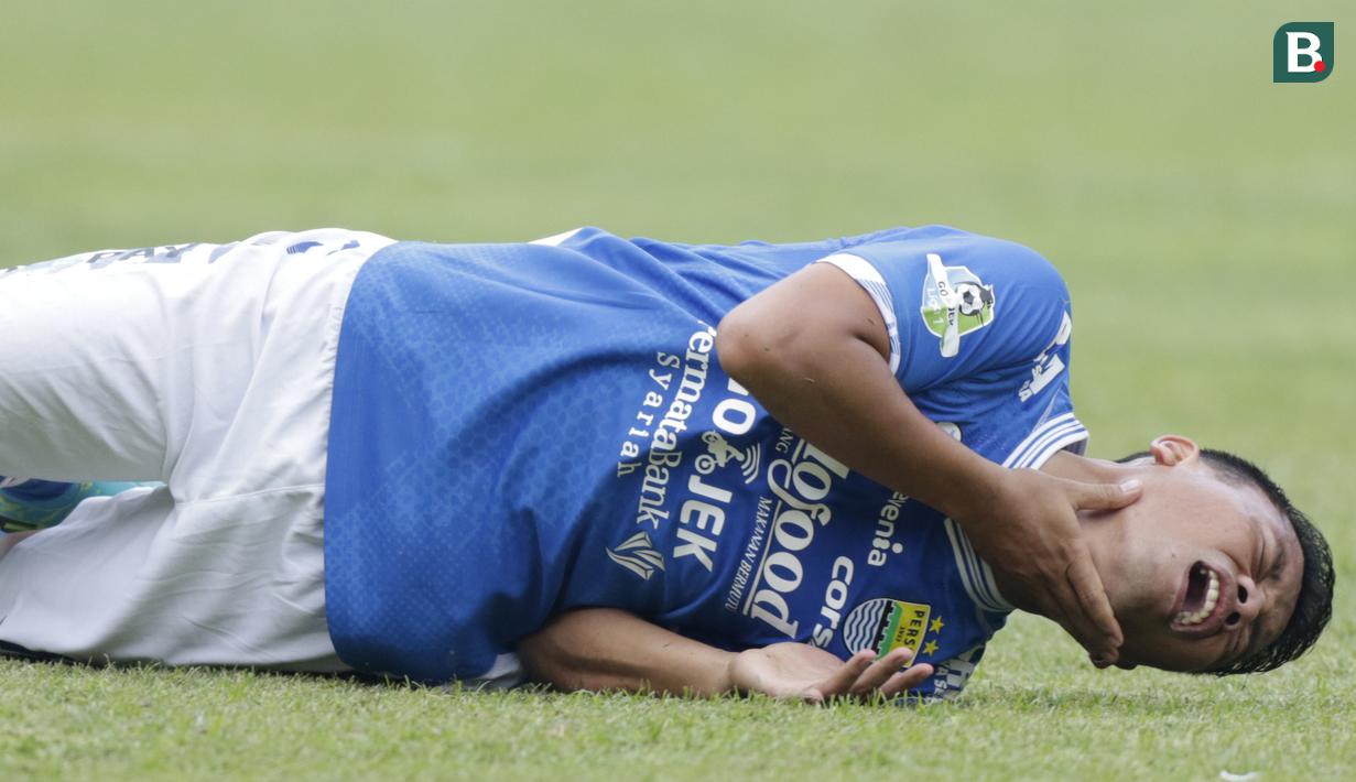 Gelandang Persib Bandung, Dedi Kusnandar, meringis kesakitan usai dilanggar pemain Persija Jakarta pada laga Liga 1 di Stadion GBLA, Jawa Barat, Minggu (23/9/2018). Persib menang 3-2 atas Persija. (Bola.com/M Iqbal Ichsan)