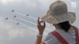 Warga menyaksikan atraksi Jupiter Aerobic Team TNI AU saat berlangsungnya pesta rakyat dalam rangka peringatan HUT TNI AU ke-72 di Lanud Halim Perdanakusumah, Jakarta, Sabtu (7/4). (Liputan6.com/Herman Zakharia)