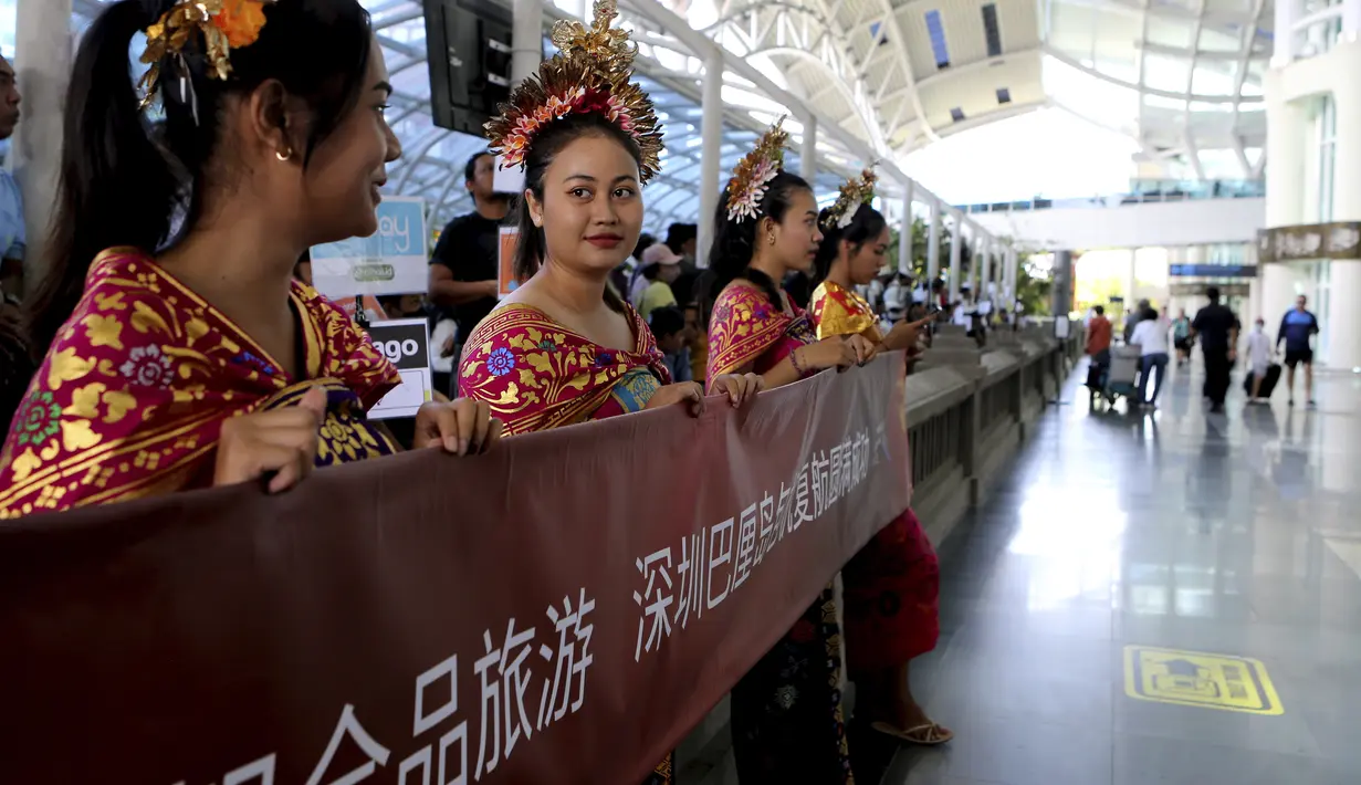<p>Perempuan berpakaian tradisional menyambut kedatangan wisatawan mancanegara (wisman) asal China di bandara internasional Ngurah Rai di Bali, Minggu (22/1/2023). Penerbangan langsung turis China mendarat di pulau Bali untuk pertama kalinya pada hari Minggu dalam hampir tiga tahun setelah ditutupnya rute penerbangan lantaran kebijakan nol Covid-19. (AP Photo/Firdia Lisnawati)</p>
