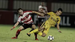 Gelandang Bhayangkara FC, Wahyu Subo Seto, terjatuh saat berebut bola dengan gelandang Madura United, Slamet Nurcahyo pada laga Liga 1 di Stadion PTIK, Jakarta, Kamis, (07/6/2018). (Bola.com/M Iqbal Ichsan)