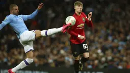 Bek Manchester City, Kyle Walker berebut bola dengan gelandang Manchester United, Brandon Williams pada pertandingan semifinal Piala Liga Inggris di stadion Etihad, Manchester, Rabu (29/1/2020). MU menang 1-0 atas City namun gagal ke final karena skor agregat 3-2. (AP Photo/Dave Thompson)