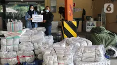 Humas PT Askrindo Eka Harumi (kiri) menyerahkan bantuan kepada perwakilan masyarakat NTT di Cargo Bandara Soekarno Hatta, Banten, Kamis (08/04/2021). PT Askrindo berpartisipasi mengirimkan bantuan tanggap bencana ke Nusa Tenggara Timur melalui CSC Garuda Indonesia. (Liputan6.com/Pool/Askrindo)
