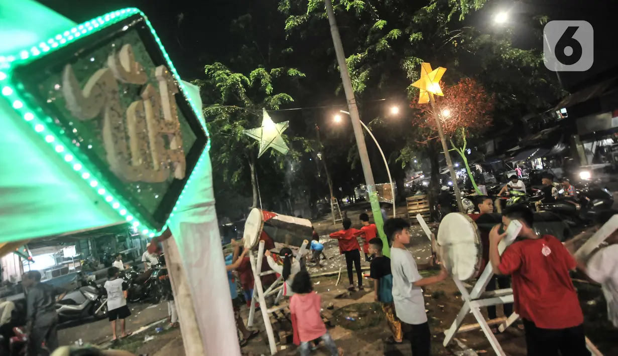 Anak-anak memainkan bedug saat merayakan malam takbiran Idul Fitri di Manggarai, Jakarta, Rabu (13/5/2021). Tradisi merayakan malam takbiran dengan memainkan bedug dan membuat hiasan bernuansa Islam masih terlihat di pinggiran Ibu Kota meski pandemi Covid-19. (merdeka.com/Iqbal S. Nugroho)