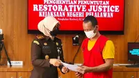 Kepala Kejari Pelalawan Silpia Rosalina saat menyerahkan surat penghentian perkara pencurian sawit. (Liputan6.com/M Syukur)