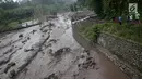 Warga mengamati aliran lahar dingin yang melintasi Sungai Yeh Sah di Karangasem, Bali, Sabtu (2/12). Banjir lahar dingin ini juga mengundang pengendara yang melintas untuk berfoto dan melihat-lihat. (Liputan6.com/Immanuel Antonius)