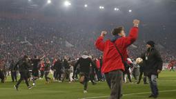 Para suporter Olympiakos turun ke lapangan merayakan kemenangan atas AC Milan pada laga Europa di Stadion Georgios Karaiskakis, Athena, Kamis (13/12). Olympiakos menang 3-1 atas AC Milan. (AP/Thanassis Stavrakis)