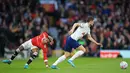 Bek Tottenham Hotspur Ben Davies (kanan) melarikan diri dari striker Manchester United (MU) Marcus Rashford (kiri) pada pekan ke-29 Liga Inggris di Old Trafford, Minggu (13/3/2022) dini hari WIB. Cristiano Ronaldo mencetak hattrick untuk membawa MU menang 3-2 atas Tottenham. (Lindsey Parnaby/AFP)