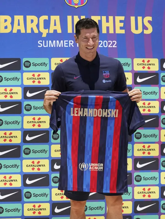 <p>Robert Lewandowski menunjukkan jersey saat diperkenalkan sebagai pemain baru Barcelona di Fort Lauderdale, Florida, Rabu (20/7/2022). Sebelum perkenalannya tersebut, sebenarnya Robert Lewandowski sudah muncul dalam laga persahabatan kontra Inter Miami di mana timnya menang telak 6-0. (AP Photo/Marta Lavandier)</p>