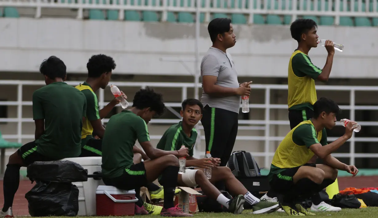 Para pemain Timnas Indonesia U-19 melepas dahaga psaat latihan di Stadion Pakansari, Bogor, Senin (30/9). Latihan ini merupakan persiapan jelang Piala AFF U-19 di Vietnam. (Bola.com/Vitalis Yogi Trisna)