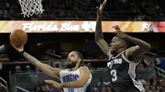Pemain Orlando Magic, Evan Fournier (kiri) melakukan lay up saat dihadang pemain San Antonio Spurs, Dewayne Dedmon #3 pada laga NBA preseason basketball di Orlando. (AP/John Raoux)