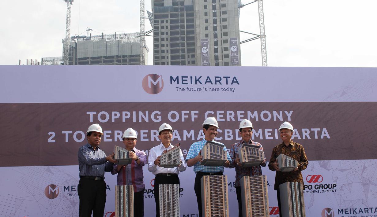 Menko Kemaritiman Luhut Panjaitan dan Presiden Meikarta Ketut Budi Wijaya (kanan) menutup miniatur tower sebagai tanda peresmian penutupan atas (toppiing off) bangunan dua tower pertama Meikarta, di Cikarang, Bekasi, Minggu (29/10). (Liputan6.com/Pool)