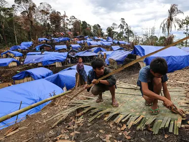 Dua orang Suku Baduy Luar sedang membuat dinding dari bambu di Kampung Cisaban II, Desa Kanekes, Banten, Kamis (01/6). Warga Baduy Luar mulai membangun kembali rumah mereka yang terbakar beberapa waktu lalu. (Liputan6.com/Fery Pradolo)