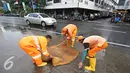 Petugas menggunakan busa untuk membersihkan genangan air di Harmoni, Jakarta, Selasa (9/2). Buruknya sistem drainase membuat petugas terpaksa harus membersihkan genangan setiap kali hujan, meski dengan peralatan seadanya. (Liputan6.com/Immanuel Antonius)