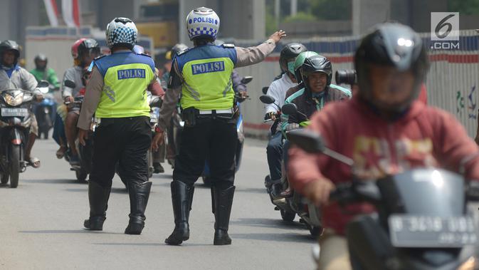 Polisi lalu lintas memberhentikan pengendara sepeda motor saat menggelar razia Operasi Patuh Jaya 2019 di kawasan Kebon Nanas, Jakarta, Kamis (29/8/2019). Diketahui, Operasi Patuh Jaya 2019 di wilayah hukum Polda Metro Jaya mulai digelar hari ini hingga 11 September 2019. (merdeka.com/Imam Buhori)