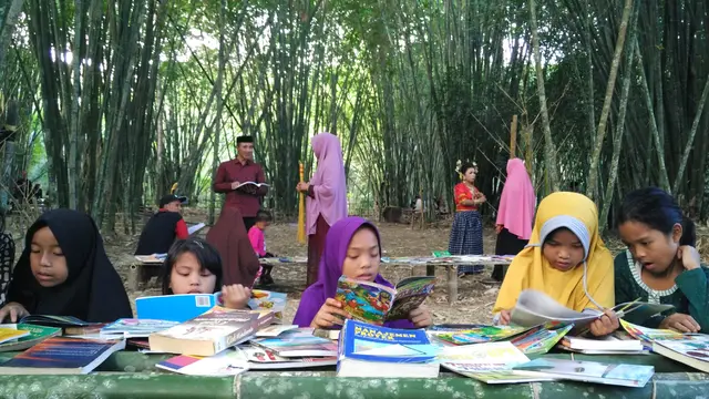 Anak-anak kecil asyik membaca buku di ajang Festival Sungai mandar Ke-V (Ahmad Yusran/Liputan6.com)
