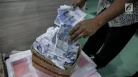Petugas Direktorat Tindak Pidana Ekonomi Khusus Bareskrim Polri memperlihatkan uang palsu saat rilis di Bareskrim Polri, Jakarta, Jumat (16/6). Dalam penangkapan polisi mengamankan 1.000 lembar uang pecahan Rp 50.000 palsu. (Liputan6.com/Faizal Fanani)