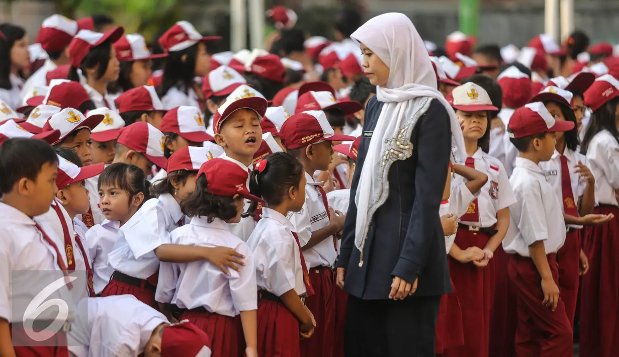 Guru mengatur para murid sebelum upacara di SD Pasar Baru 05, Jakarta, Senin (27/7/2015). Usai libur panjang Idul Fitri para siswa kembali beraktivitas mengikuti pelajaran di sekolah untuk tahun ajaran 2015-2016. (Liputan6.com/Faizal Fanani)