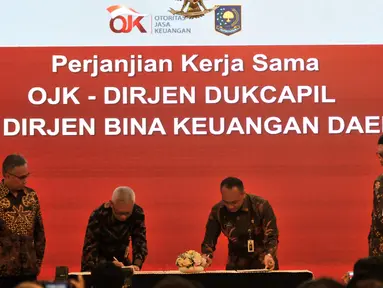 Mendagri Tjahjo Kumolo (kanan) didampingi Ketua Dewan Komisioner OJK Wimboh Santoso saat menyaksikan Dirjen Dukcapil dan Dirjen Bina Keuangan Daerah melakukan penandatanganan Nota Kesepahaman di Jakarta, Selasa (19/2). (Merdeka.com/Iqbal Nugroho)