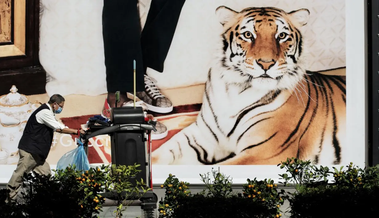 Seorang pekerja berjalan melewati iklan yang menampilkan macan di depan pusat perbelanjaan jelang Tahun Baru Imlek di Taipei, Taiwan, Kamis (27/1/2022). Tahun Baru Imlek 2022 yang jatuh pada 1 Februari mendatang akan jadi tahun shio macan. (Sam Yeh/AFP)