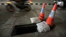 Pembatas jalan berwarna oranye diletakkan dekat penutup lubang saluran air yang hilang di Underpass Mampang-Kuningan, Jakarta, Kamis (23/8). Petugas menyadari hilangnya penutup saluran air itu usai salat Idul Adha. (Merdeka.com/Iqbal S. Nugroho)