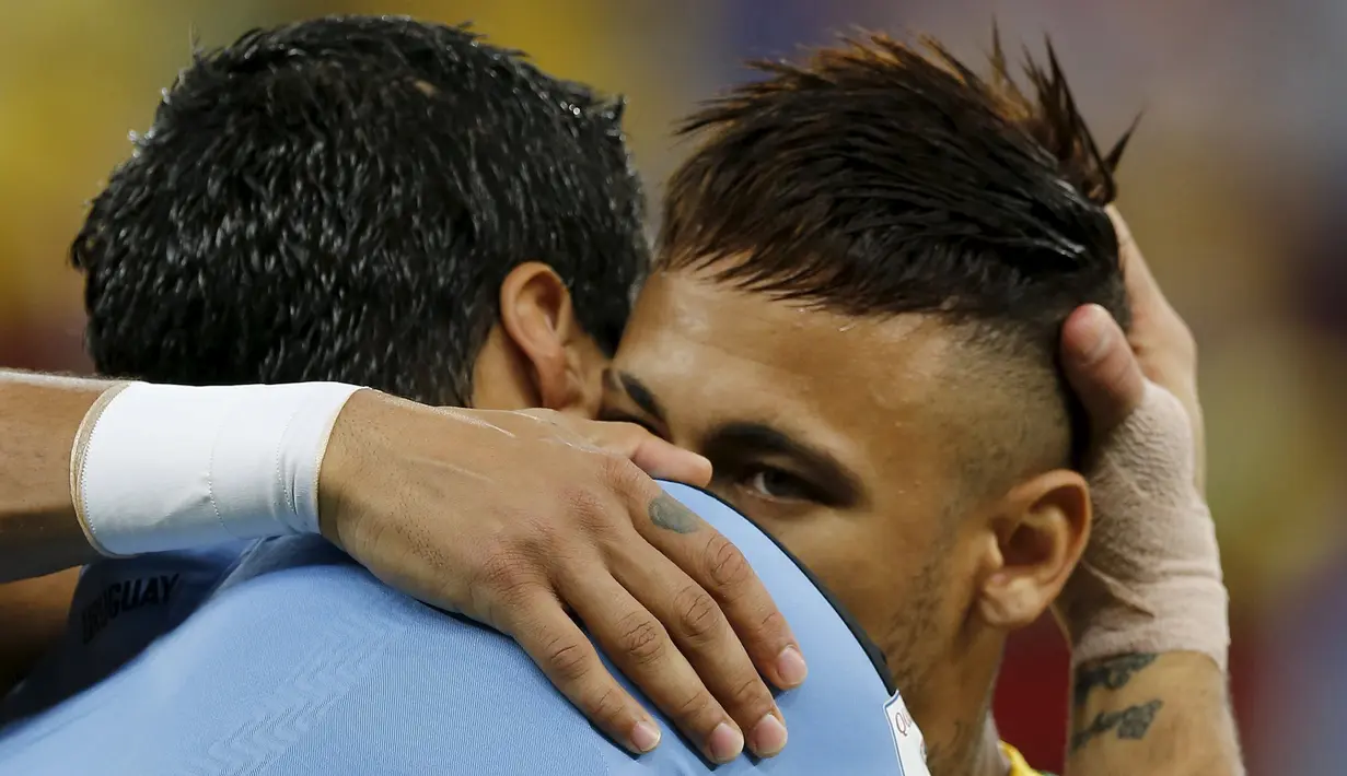 Penyerang Brasil, Neymar (kanan) saat berpelukan dengan Penyerang Uruguay, Luis Suarez saat pertandingan kualifikasi Piala Dunia di Brasil, (25/3). Kedua pemain ini sama-sama membela Barcelona di level tim. (REUTERS / Paulo Whitaker)