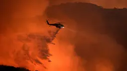 Helikopter menumpahkan air untuk memadamkan pada kebakaran hutan yang terjadi di Calabasas , California , AS , 4 Juni 2016. Ribuan warga di evakuasi ketempat lebih aman untuk menghindari korban jiwa.  ( REUTERS / Gene Blevins)