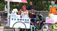 Seorang pedagang es doger menjajakan dagangannya di sisi jalan sekitar kawasan Patung Kuda Jakarta, Rabu (5/1/2019). Mereka mencoba peruntungan saat para buruh melakukan aksi perayaan Hari Buruh International atau May Day. (Liputan6.com/Helmi Fithriansyah)