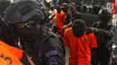 Polisi bersenjata lengkap mengawal sejumlah terduga teroris untuk dihadirkan dalam jumpa pers di Mabes Polri, Jakarta, Jumat (17/5/2019). Sepanjang bulan Mei 2019, tim Densus 88 Antiteror telah menangkap sebanyak 29 terduga teroris jaringan Jamaah Ansharut Daulah (JAD). (Liputan6.com/Johan Tallo)