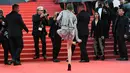 Kristen Stewart melepas sepatunya di karpet merah pemutaran film BlackKkKlansman pada Festival Film Cannes, Prancis, Senin (14/5). Ini merupakan bentuk protesnya atas kebijakan panitia yang melarang mengenakan sepatu flat. (AFP/ANNE-CHRISTINE POUJOULAT)