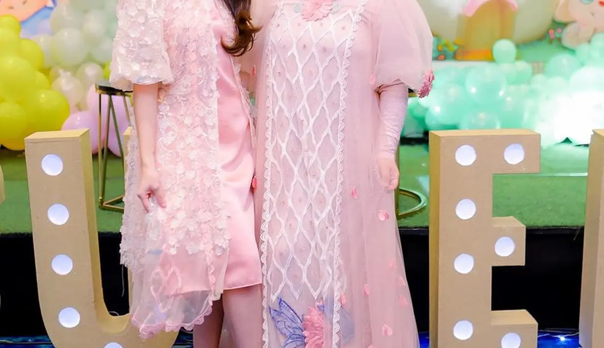 Dress tersebut dipadukan heels dengan strap waena pink. Sementara Syida mengenakan dress panjang tulle lengan balok dengan aksen bordiran dan bunga 3D, serasi dengan kerudungnya. [@ayutingting92]