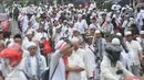 Puluhan orang berjalan kaki menuju Monas dari arah Tanah Abang, Jakarta, Jumat (2/12). Mereka terlihat berbondong-bondong berjalan untuk mengikuti demo 2 Desember di Lapangan Monas. (Liputan6.com/Helmi Afandi)