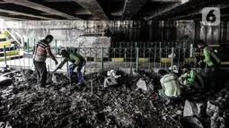 Petugas Suku Dinas Pertamanan Jakarta Pusat menyelesaikan pembangunan taman di kolong Jembatan Pegangsaan, Jakarta, Selasa (19/1/2021). Selain taman, nantinya kolong jembatan tersebut akan dilengkapi lampu-lampu, kolam ikan, dan area memancing. (merdeka.com/Iqbal S. Nugroho)