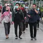 Sejumlah orang berjalan di trotoar pada saat jam pulang kantor di Kawasan Sudirman, Jakarta, Senin (8/6/2020). Aktivitas perkantoran dimulai kembali pada pekan kedua penerapan Pembatasan Sosial Berskala Besar (PSBB) transisi pandemi COVID-19. (Liputan6.com/Johan Tallo)
