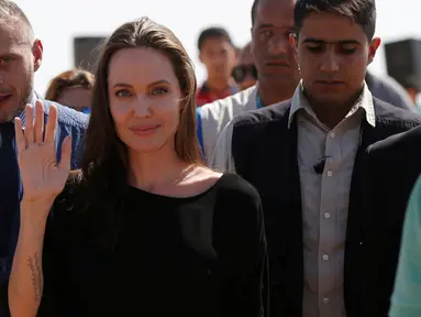 Angelina Jolie melambaikan tangan kepada awak media saat berkunjung ke kamp pengungsi Azraq untuk Suriah, Yordania, Jumat (9/9). Jolie menyebut reputasi PBB saat ini telah dirusak oleh oknum pasukan penjaga perdamaian. (REUTERS / Muhammad Hamed)