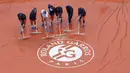 Petugas mengeringkan lapangan dari air hujan yang mengguyur kompleks Roland Garros, tempat berlangsungnya turnamen tenis grand slam Prancis Terbuka, Minggu (22/5/2016). (Reuters/Pascal Rossignol)