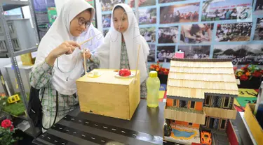 Dua murid SMP mencoba cara kerja dinamo listrik saat kegiatan Puspiptek Innovation Festival (PIF) 2018 di kawasan Puspiptek, Setu, Tangerang Selatan, kamis (27/9). PIF 2018 berlangsung hingga 30 September. (Merdeka.com/Arie Basuki)