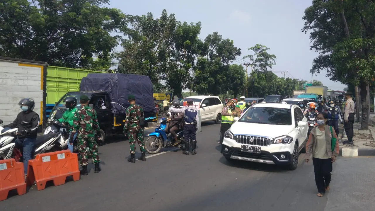 Petugas memutarbalikkan kendaraan ke arah asal di Jalan Daan Mogot yang menghubungkan Kota Tangerang dengan DKI Jakarta saat PPKM Darurat.