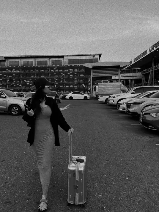 Azizah Salsha juga kenakan fitted dress abu-abu dengan cardigan hitam sambil menggeret koper [@azizahsalsha_]